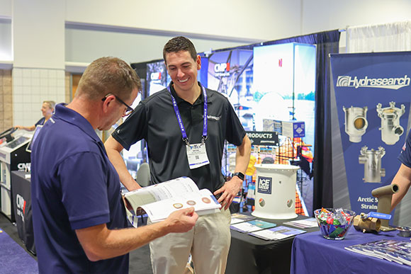 Representante da Hydrasearch conversando com um participante do evento.