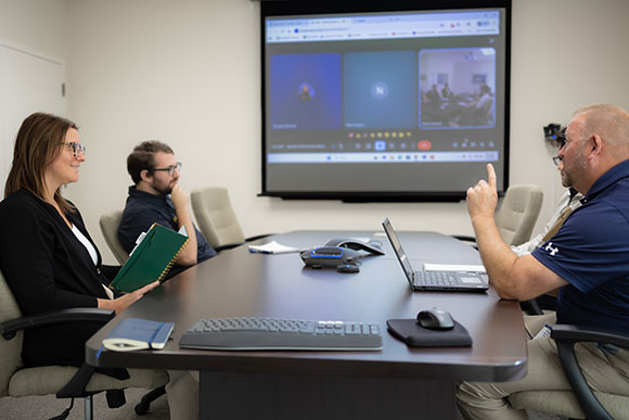 Funcionários da Hydrasearch em sala de reuniões
